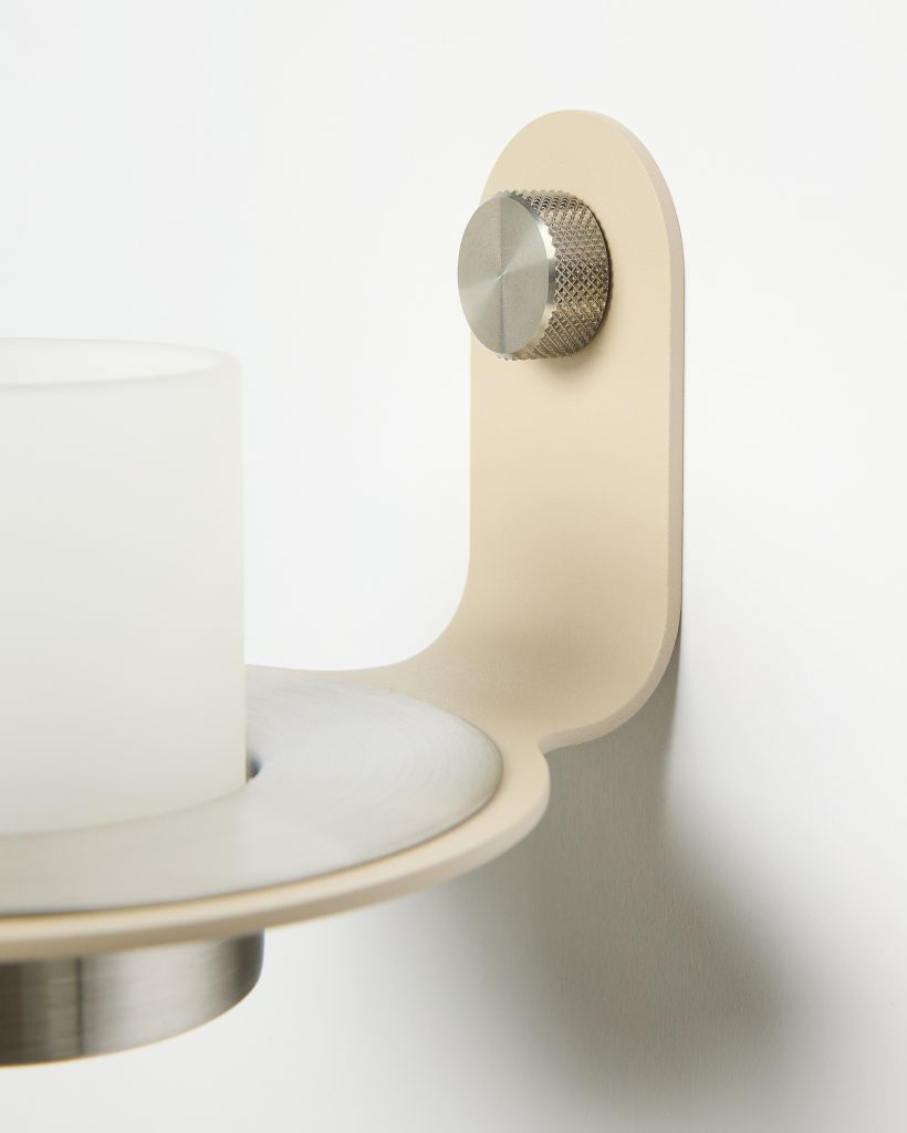 Immagine di un portacandela WoodUpp: applique a parete in metallo color beige opaco con mensola circolare compatta, supporto con manopola zigrinata in acciaio satinato e un bicchiere porta‑candela in vetro satinato opaco bianco, profilo arrotondato, design minimale ed eleganti finiture spazzolate, dallo stile contemporaneo.